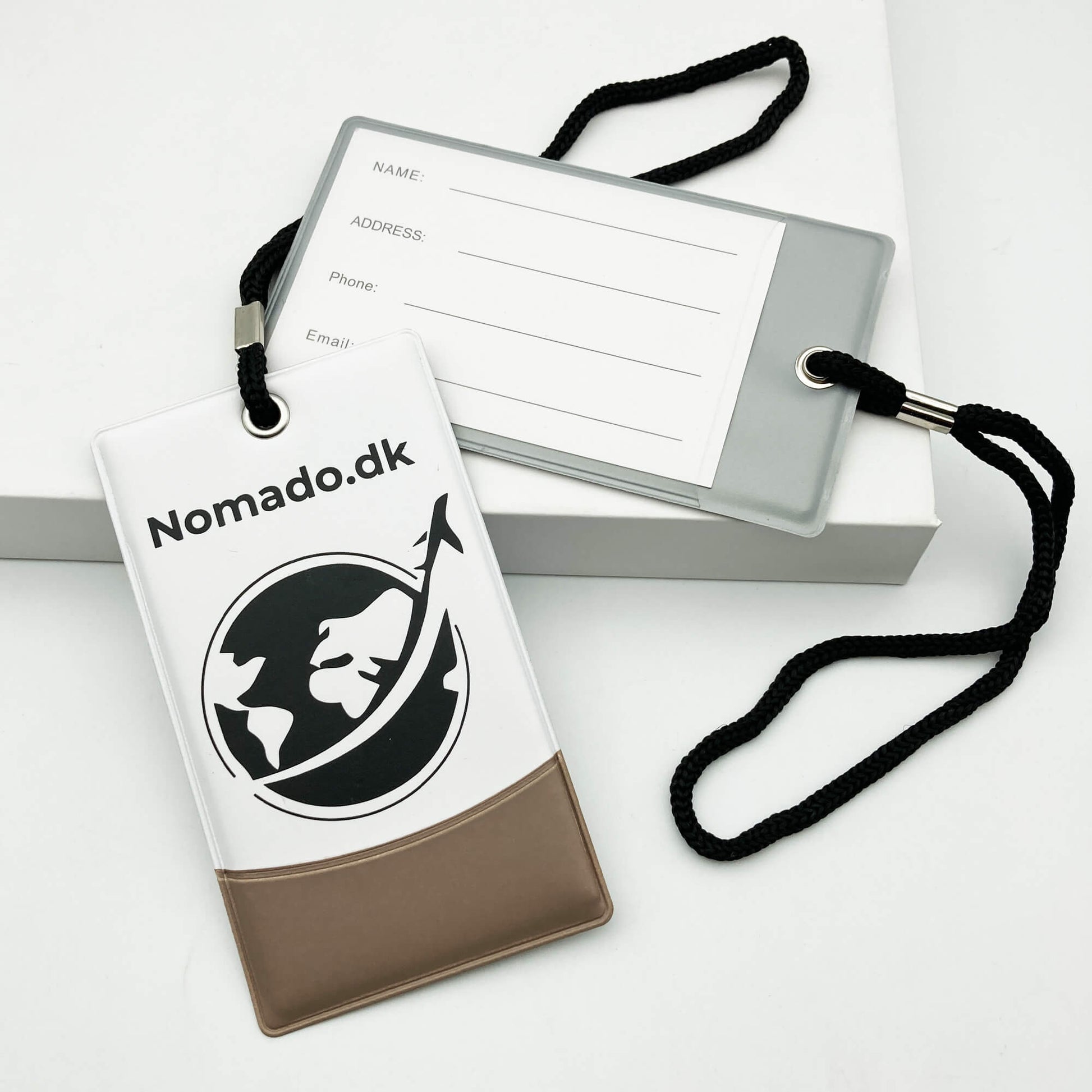 Nomado kuffertmærker: Blå mærke med logo, grå med kontaktinfo